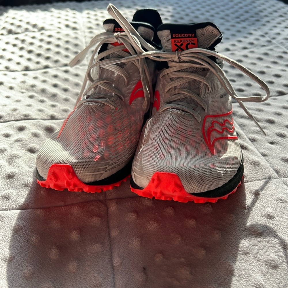 White and pink Saucony spikes (spikes not included)